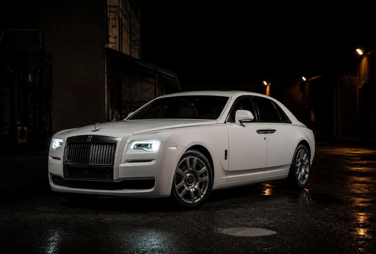 White Rolls-Royce Ghost parked on a dark UK location at night